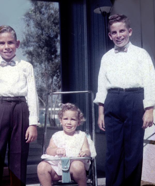 Judy in her stroller with 2 brothers